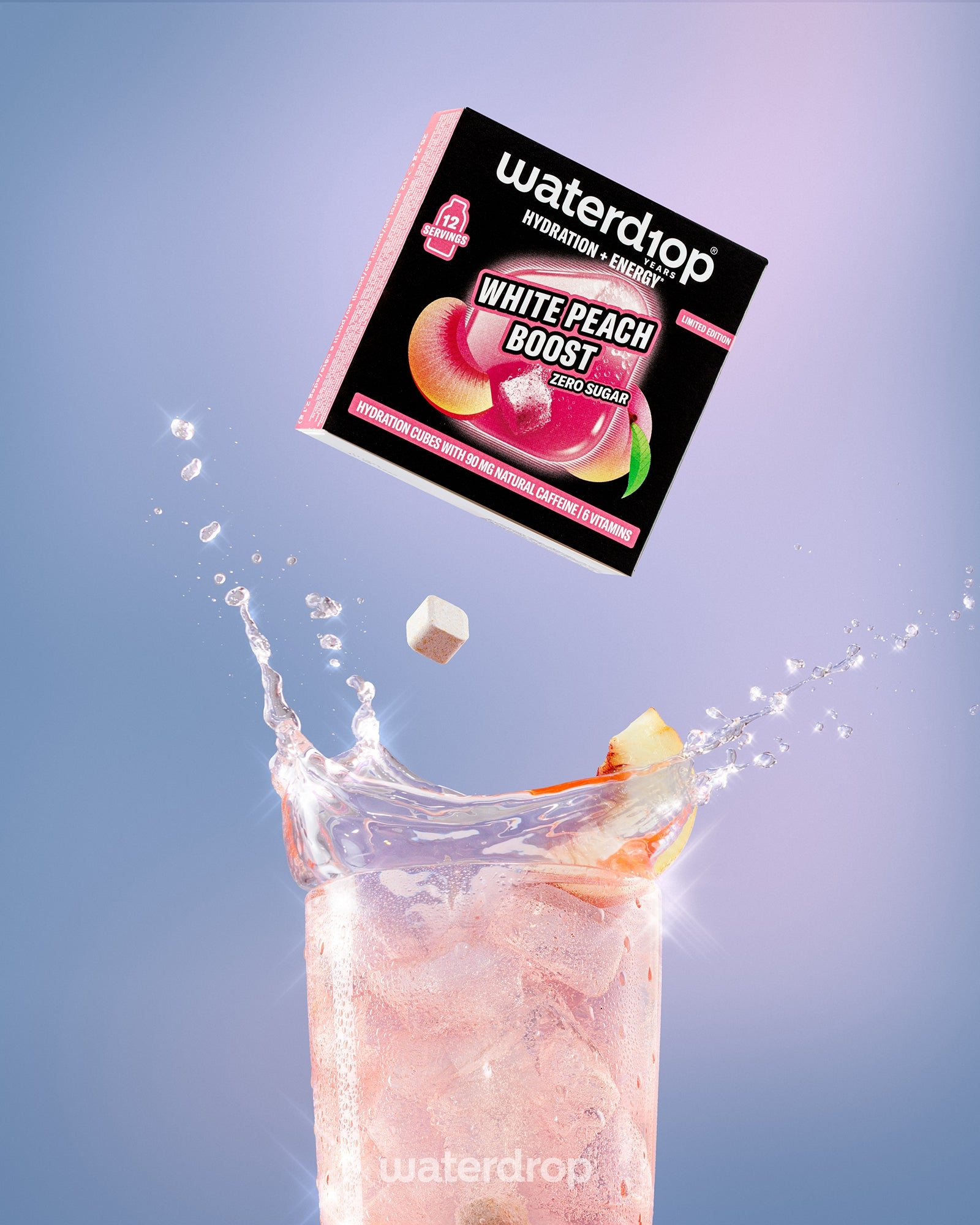 Kutija napitka White Peach Boost iznad visoke čaše ružičaste napitke sa ledom.