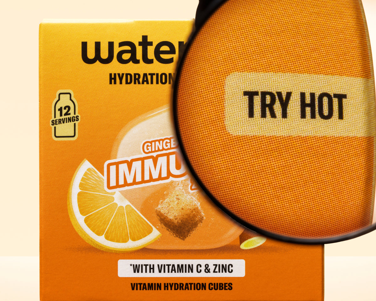 Narančasta kutija sa grafikom limuna i povećalom iznad nje, promovi kocke za hidrataciju sa vitaminom C i cinkom.